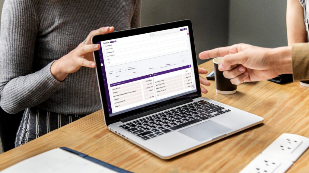 Zwei Personen besprechen Produktentwicklungsdaten in der geöffneten UMYNO Software-Plattform auf einem Laptop.